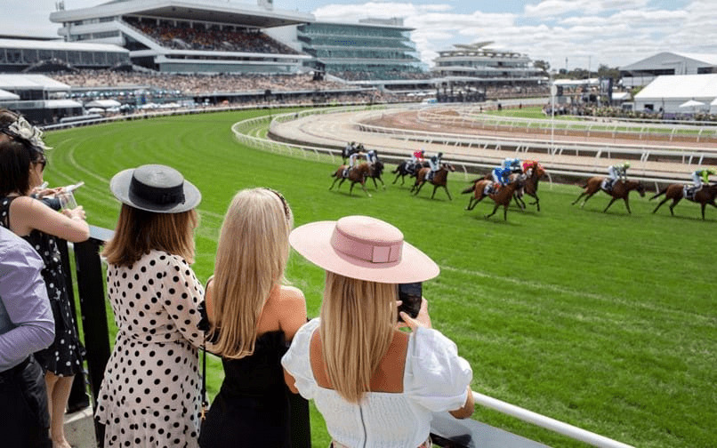 People enjoying the Melbourne Cup at the Spring Carnival, watching the horse racing in style.